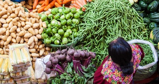 Woman sells vegetables at a traditional weekly market