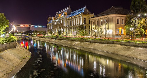 Walk along the water while admiring the Palace of Justice in Bucharest
