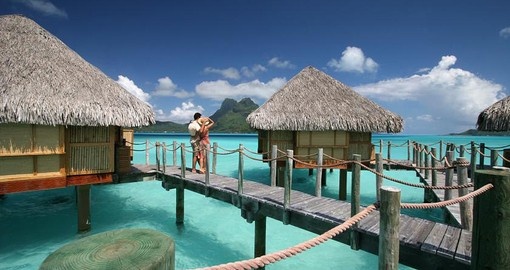 Stroll along the wooden walkways connected to the overwater bungalows during your Trips to Tahiti.