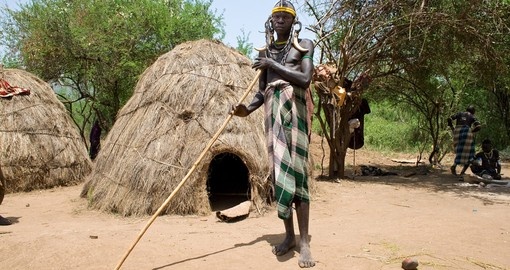 Man of the Mursi tribe in front of his hut