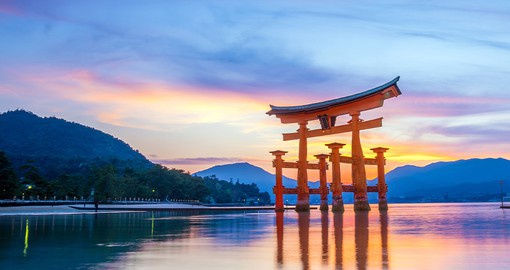 Take a detour to Miyajima Island to explore its ancient architecture, lush forests. and iconic floating gate