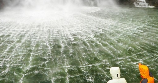 Boat near a spectacular waterfall