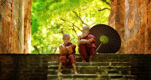Young Buddhist monks reading outdoors