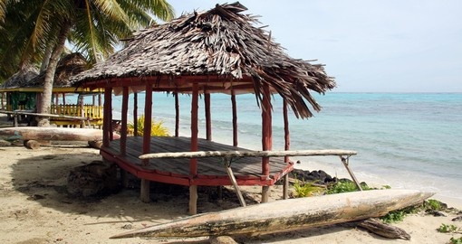 Huts and boat on a sandy beach on Savaii