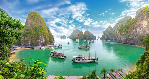 Limestone pillars and tiny islands dot the emerald waters of Halong Bay