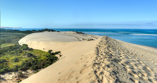 Hike the soft sand dunes of Mozambique for a breathtaking view of the water
