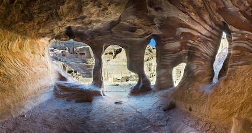 Explore the ancient town of Petra, with intricate caves carved from the surrounding rock