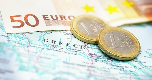 Euro coins on a map of Greece
