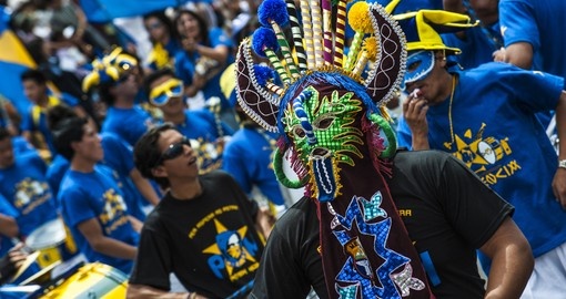 Ecuadorean masks dance as part of a parade through the street