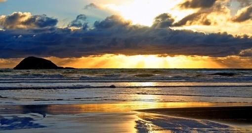 Enjoy a beautiful sunset at Maori Bay during your next New Zealand vacations.