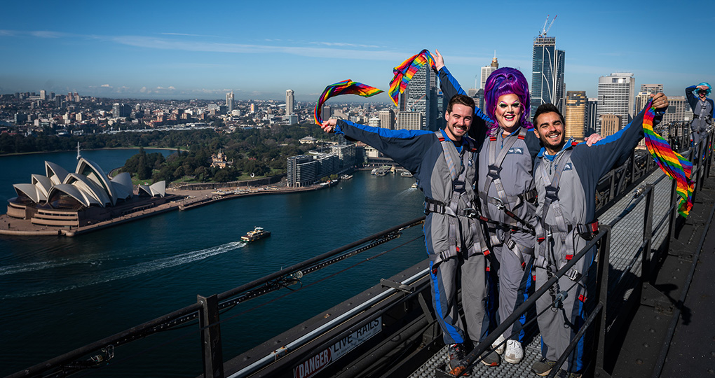 Two men with a drag queen on top of Sydney Harbour Bridge