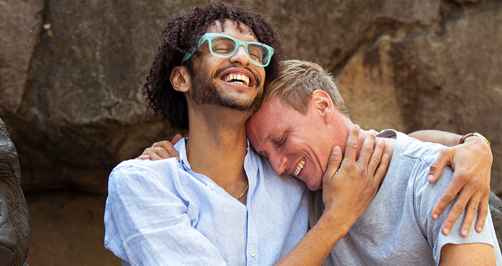 Male couple cuddling and smiling